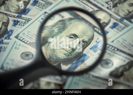 Concept de finance et de banque de capital, Portrait de Benjamin Franklin dans une loupe, des factures de cent dollars Banque D'Images