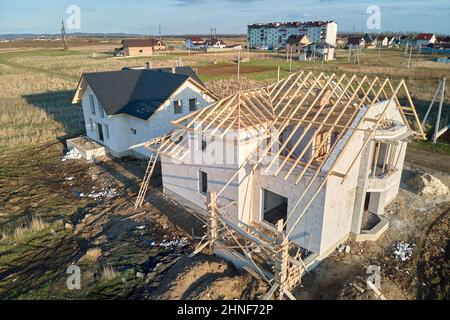 Vue aérienne du cadre inachevé de la maison privée avec murs en béton léger aéré et cadre de toit en bois en construction. Banque D'Images