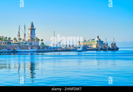 Le matin tôt dans le port avec une vue sur la surface d'eau cristalline, le phare de la Farola, les yachts et les navires, Malaga, Costa Del sol, Espagne Banque D'Images