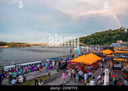 Pont piétonnier de l'autre côté de la rivière Dniepr avec une rue bondée Banque D'Images