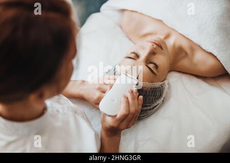 Belle femme recevant l'échographie cavitation peeling facial. Beauté de la peau. Soins de beauté. Traitement médical. Banque D'Images