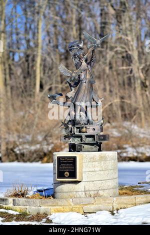 St. Charles, Illinois, États-Unis. Une statue, « New freinds » de George Lundeen, dresse un ruisseau au bord d'un parc, gelé dans le temps, comme son environnement hivernal. Banque D'Images