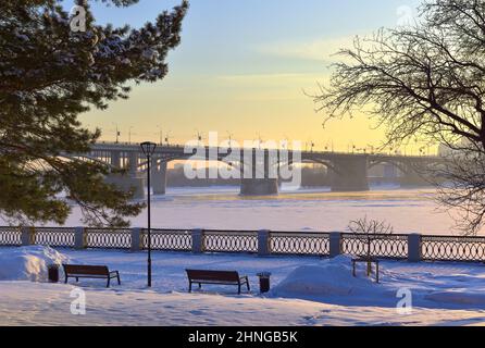 Remblai d'hiver dans la soirée. Pont d'arche communal au-dessus de la rivière OB recouverte de glace. Novosibirsk, Sibérie, Russie, 2022 Banque D'Images