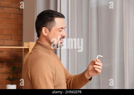 Homme avec une cigarette cassée à la maison. Concept de refus de mauvaise habitude Banque D'Images