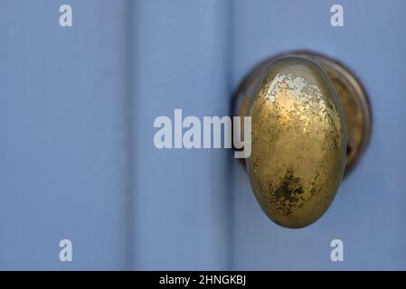 Porte d'entrée en bois bleu clair avec un ancien bouton en laiton à Nafplio, Grèce. Banque D'Images