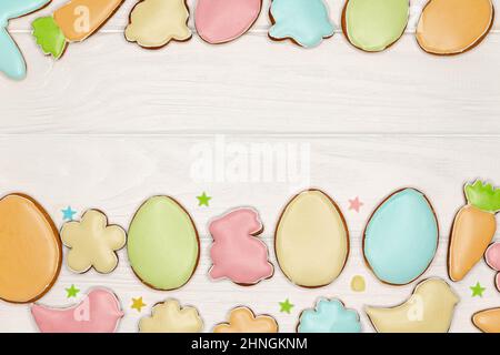 Délicieux biscuits de pâques colorés sur fond de bois blanc. Banque D'Images