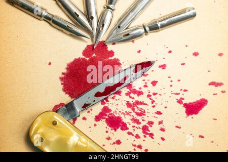 Une armée de pointes de stylo à bille et d'encre rouge renversée sur une lame de couteau, représentant la célèbre citation : « un stylo est plus puissant qu'une épée ». Mise au point sélective créative Banque D'Images