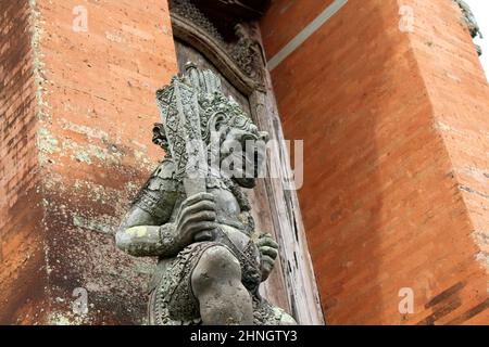 Statues de gardien tenant une arme à l'entrée du Temple Taman Ayun, Bali. Prise janvier 2022. Banque D'Images