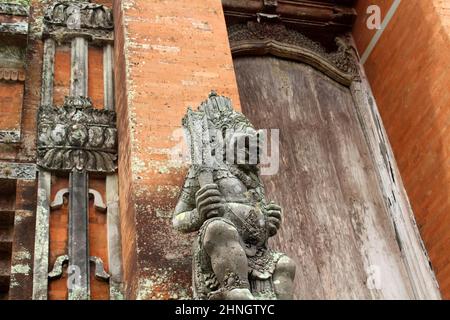 Statues de gardien tenant une arme à l'entrée du Temple Taman Ayun, Bali. Prise janvier 2022. Banque D'Images