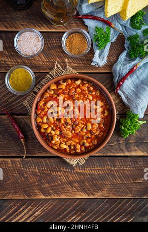 Chili con carne dans un bol sur fond de bois. Cuisine mexicaine. Vue de dessus Banque D'Images