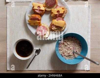 Vue de dessus le matin petit déjeuner avec porridge, sandwichs et une tasse de café. Banque D'Images