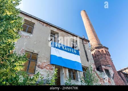 Façade de vieux bâtiment pittoresque avec cheminée et panneau de vente (en allemand) Banque D'Images
