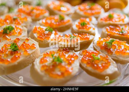 Assiette avec sandwichs au caviar rouge sur la table des fêtes Banque D'Images