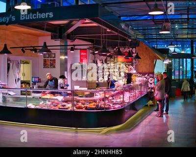 Comptoirs de boucher locaux et leurs clients dans le nouveau Market Hall de Preston, Lancashire, Royaume-Uni. Banque D'Images