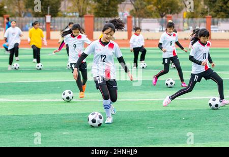 HAI'AN, CHINE - 17 FÉVRIER 2022 - les enfants d'un club de football pour filles dans une école primaire pratiquent les compétences de base pendant les heures de service après l'école à Ha Banque D'Images