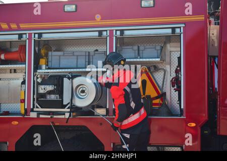 Pompier quittant le camion d'incendie avant de déclencher un incendie Banque D'Images