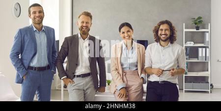 Portrait d'une équipe d'affaires créative debout ensemble et riant à la réunion dans le centre d'affaires. Banque D'Images