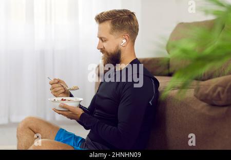 L'homme athlétique après un entraînement sportif actif matinal mange des aliments sains pour restaurer l'énergie. Banque D'Images