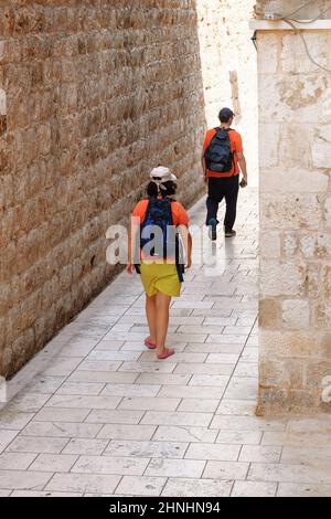 Les touristes marchent dans l'endroit historique en plein jour. Partie historique de la ville. Passage entre les murs de la vieille ville. Été en Croatie, Dubrov Banque D'Images