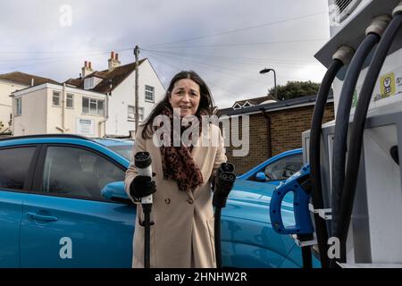 Femme d'âge moyen utilisant le point de charge de véhicule 'GeniePoint EV Charging' dans Hampshire , Angleterre, Royaume-Uni Banque D'Images