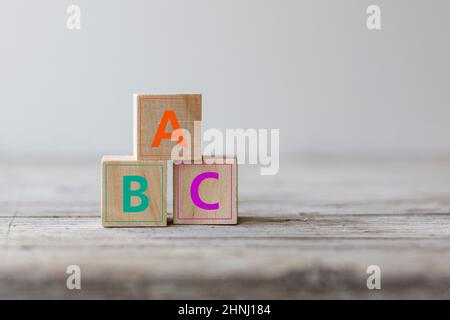 Notion d'analphabétisme. Lettres ABC sur blocs de cube en bois sur une table en bois Banque D'Images
