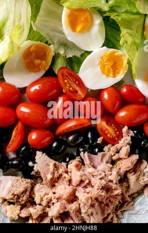 Gros plan de la salade niçoise traditionnelle avec thon en conserve, olives, tomates cerises et œufs. Vue de dessus de la nourriture Banque D'Images