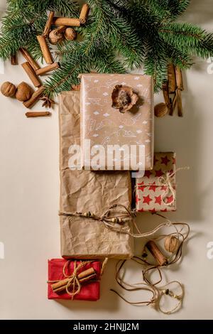 Collection de boîtes-cadeaux de Noël en papier recyclé écologique décoré de noix naturelles et de bâtons de cannelle sur fond de papier beige avec Banque D'Images
