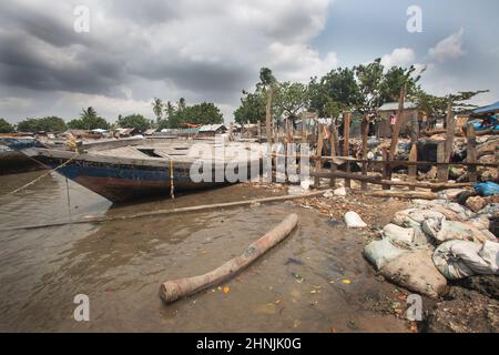 Kunduchi un petit village de pêcheurs en Tanzanie. Dans une tentative désespérée de protéger le village Machamo Hassan a construit une défense contre les vagues en utilisant du bois de grève et des sacs pleins de déchets en plastique qui se lave sur les rives. Il sait que cela ne va pas vaincre la montée des vois, mais lui et sa famille n'ont pas d'autre endroit où aller. Banque D'Images