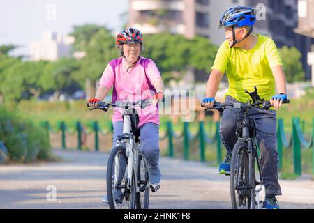 Joyeux couple senior s'entraîner avec des vélos dans le parc Banque D'Images