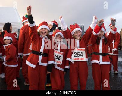 Des filles qui participent à la course de Santa Run de Helensburgh pour la charité, en Écosse Banque D'Images