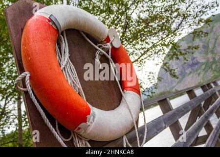 Bouée de sauvetage orange au bord du lac Vangsmjøse en Norvège. Banque D'Images