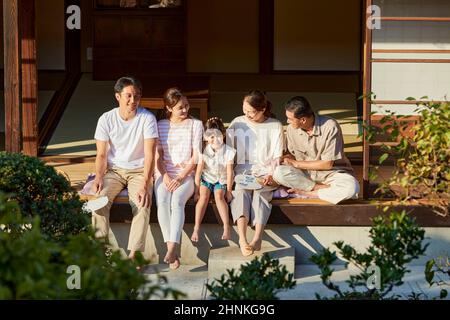 Famille japonaise de trois générations assise sur le porche Banque D'Images