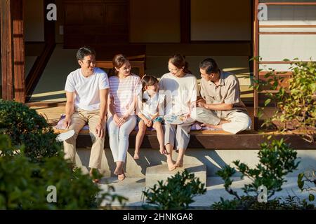 Famille japonaise de trois générations assise sur le porche Banque D'Images