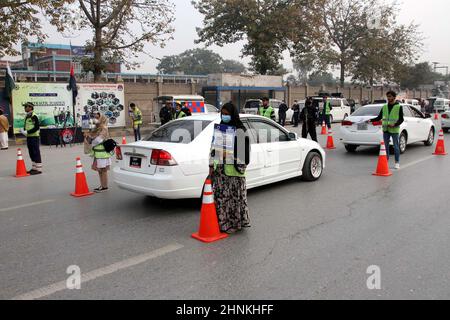 Les participants de Traffic Volunteers Body tiennent des brochures de sensibilisation et des planches de palissade sur la sécurité routière pendant la campagne de sensibilisation aux lois de la circulation et à la sécurité routière, à Peshawar, le jeudi 17 février 2022. Banque D'Images