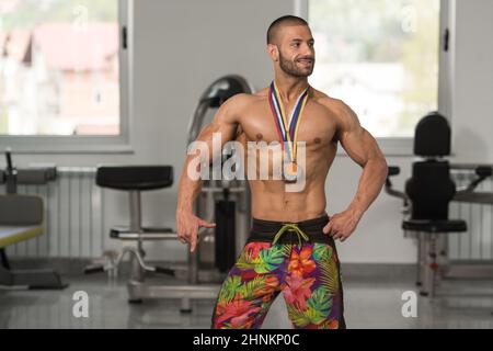 Fitness homme montrant son concurrent Médaille gagnante Banque D'Images