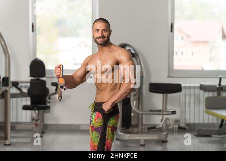 Jeune homme concurrent montrant sa médaille gagnante Banque D'Images