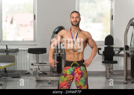 Fitness homme montrant son concurrent Médaille gagnante Banque D'Images