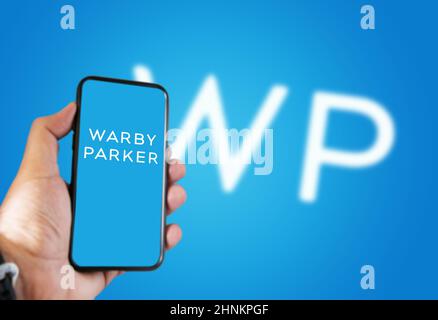 Main tenant un téléphone avec l'application mobile Warby Parker à l'écran Banque D'Images