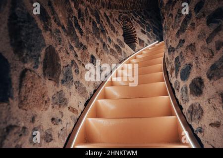 escalier étroit éclairé montant dans une tour en pierre Banque D'Images