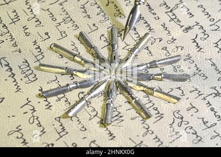 Gros plan sur des pointes métalliques et un vieux stylo sur une écriture vintage.Stylo plume sur une ancienne lettre manuscrite.Ancienne histoire.Style rétro Banque D'Images