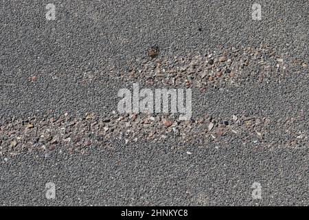 Vue détaillée sur les surfaces asphaltées de différentes rues et routes présentant des fissures en gros plan Banque D'Images