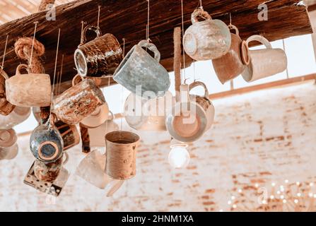 Collection de tasses en céramique accrochées aux cordes de plafond dans le café-restaurant Banque D'Images