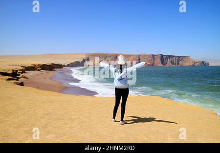 Visiteur féminin impressionné par la plage Rouge ou Playa Roja de la réserve nationale de Paracas dans la région de l'ICA, Pérou, Amérique du Sud Banque D'Images