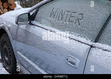 L'hiver sur la route. Une voiture pleine de neige et de glace Banque D'Images