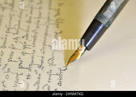 Stylo plume sur papier avec texte encreur sur écriture vintage.Gros plan.Stylo plume sur une ancienne lettre manuscrite Banque D'Images