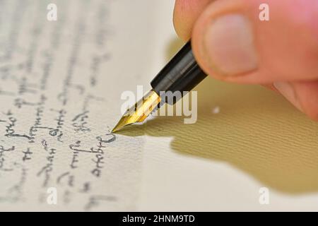 Style ancien.Lettre manuscrite avec stylo plume.Gros plan d'une main mâle prête à écrire avec un élégant stylo plume Banque D'Images