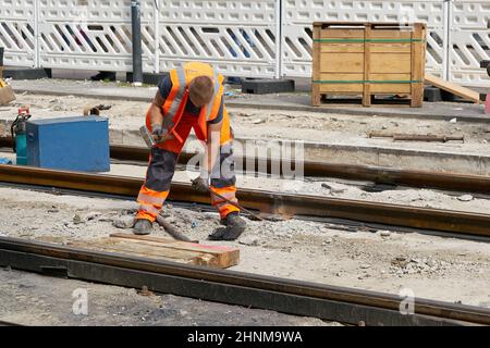 Un travailleur qui renouvelle les anciennes voies du tramway à Alexanderplatz à Berlin Banque D'Images