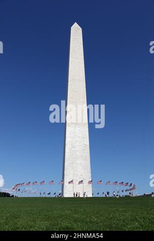 Washington Memorial montrant un cercle de drapeaux dans le ciel bleu Banque D'Images