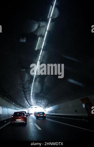 Voitures sur une autoroute traversant un long tunnel moderne (mouvement image floue image couleur tons) Banque D'Images