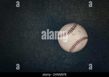 Gros plan sur une vieille balle de baseball vintage avec couture rouge sur fond brun foncé grunge avec espace pour copier, vue surélevée, juste au-dessus Banque D'Images